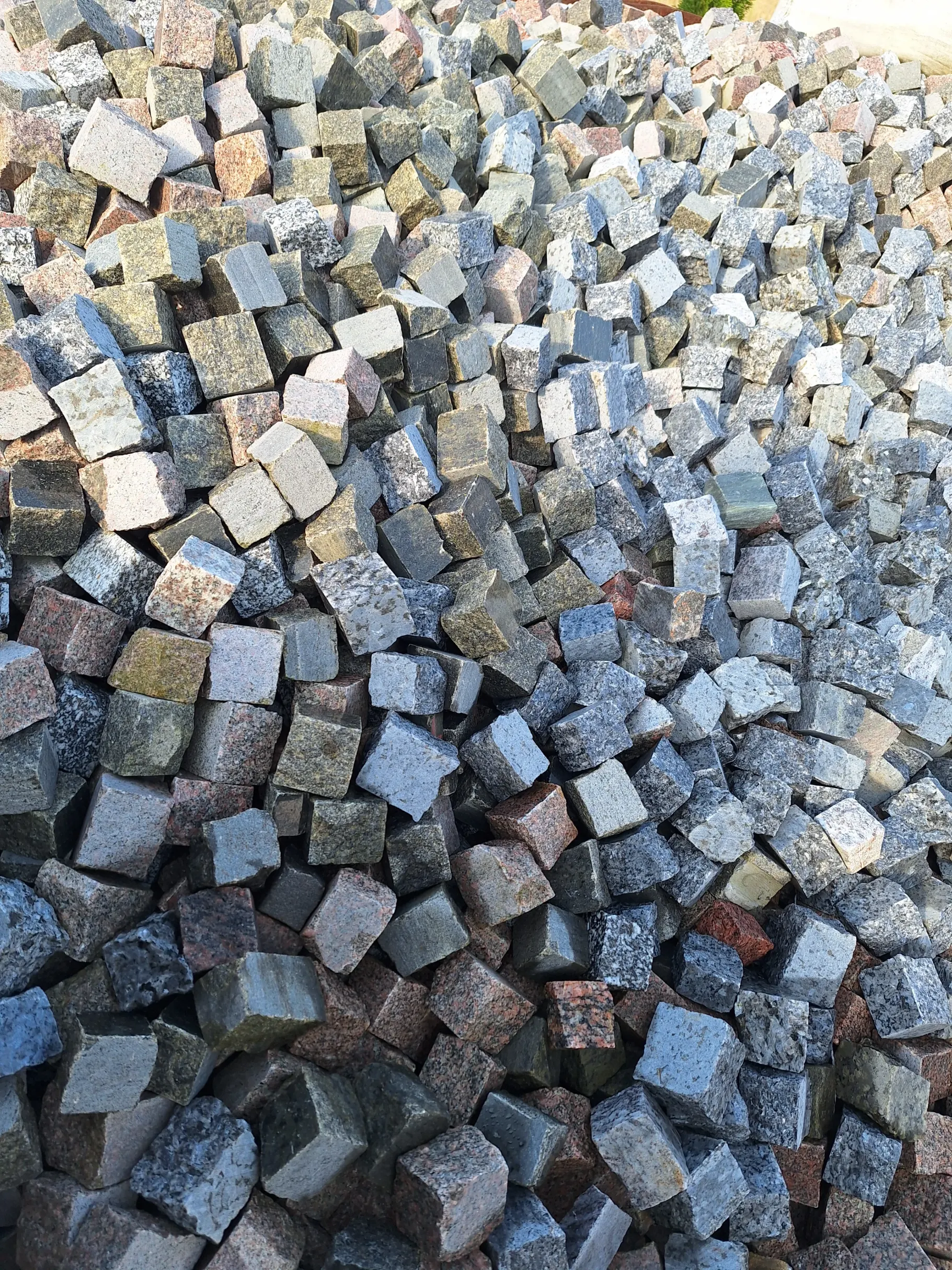 Stos surowych kostek granitowych przygotowanych do układania (Granitoidy)
