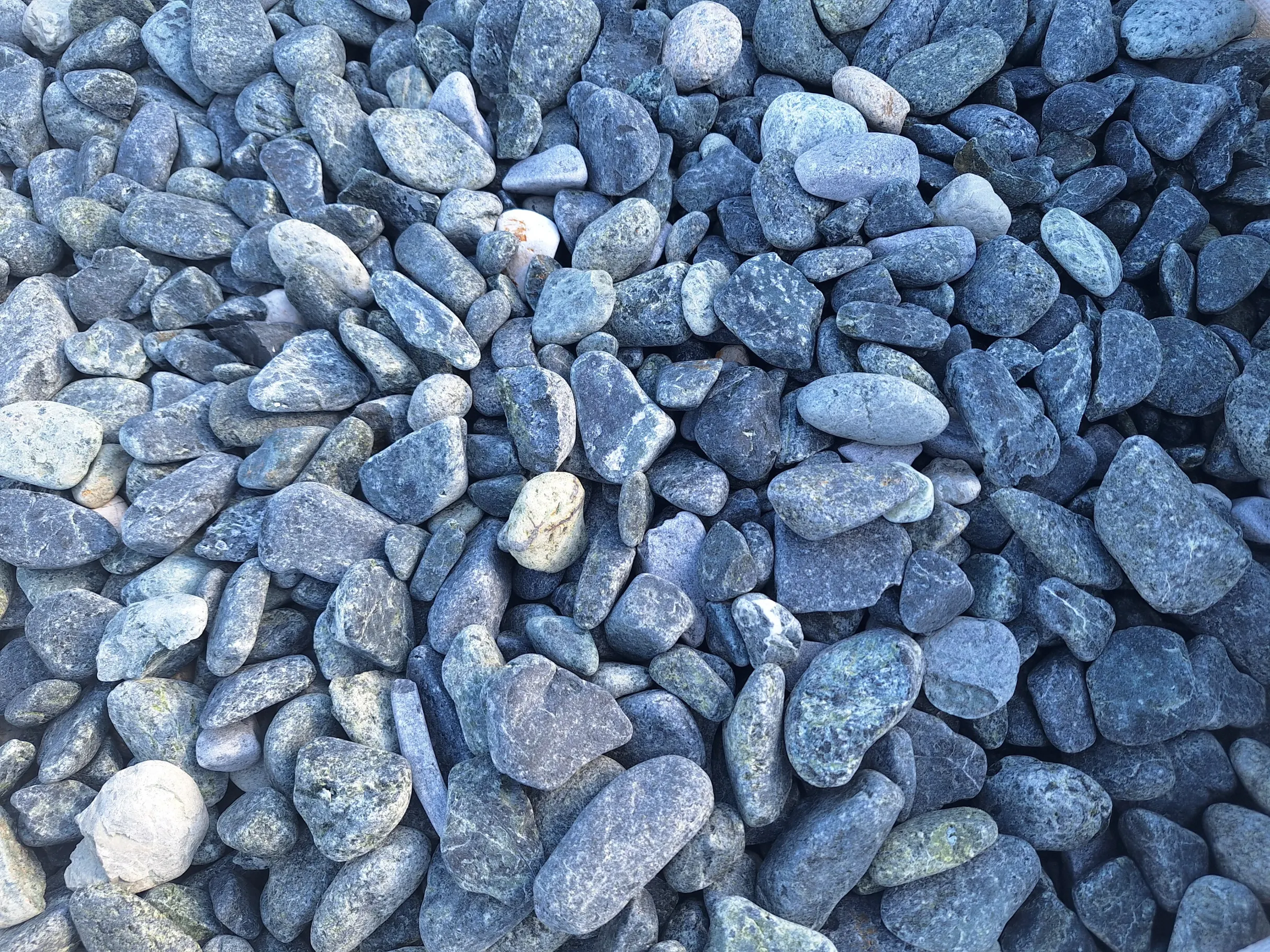 Zestaw gładkich niebiesko-szarych kamieni ozdobnych o różnych kształtach i rozmiarach