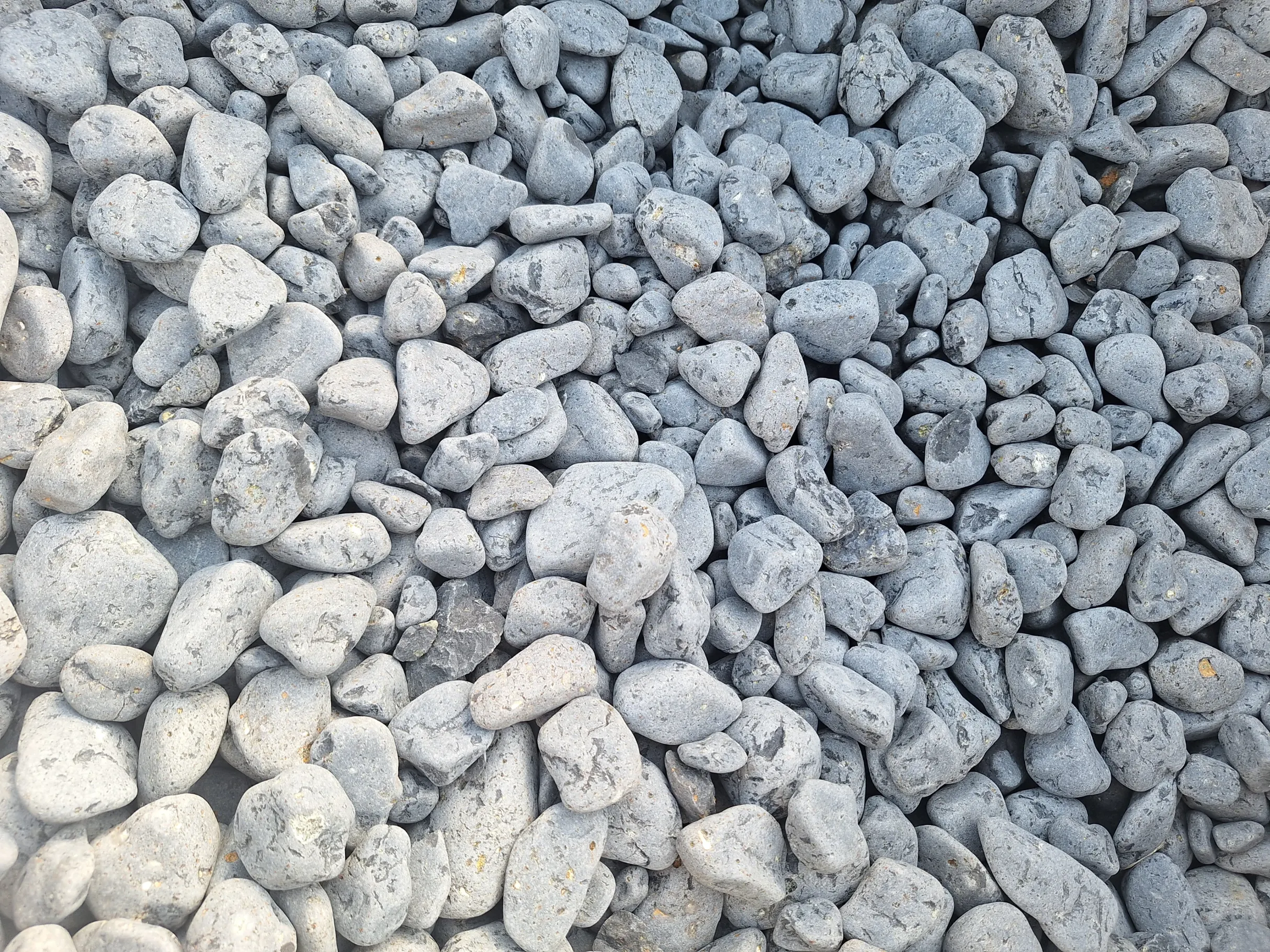 Zagęszczony nasyp gładkich, szarych otoczaków bazaltowych