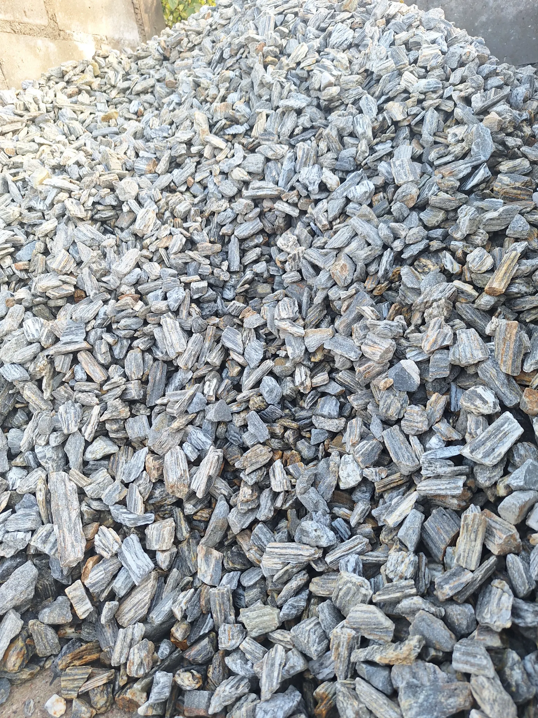 Grys szary o nieregularnych kształtach ułożony w kopcu jako dekoracyjny kamień ogrodowy