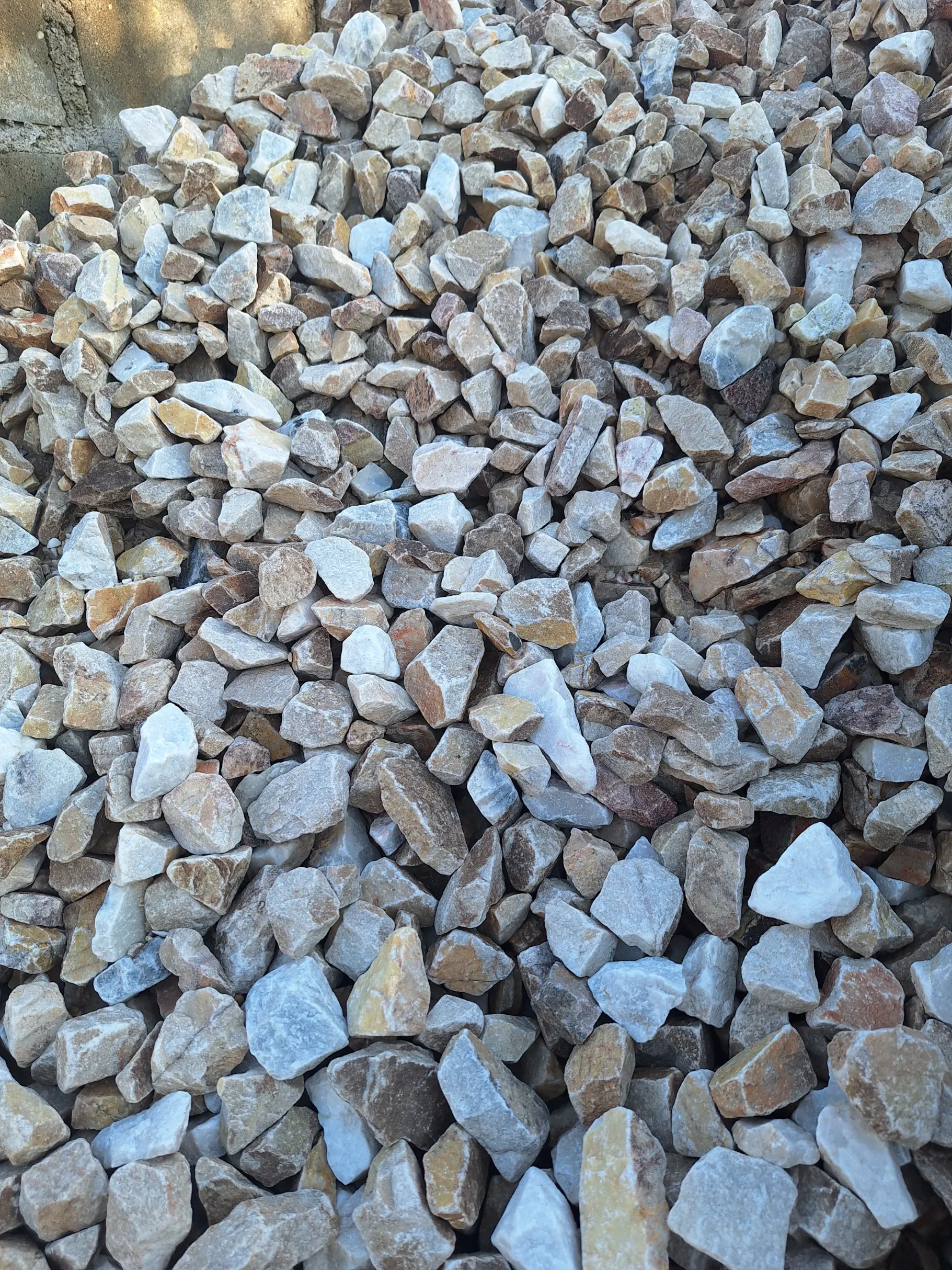 Drobny grys w nieregularnych bryłkach w bieli i beżu ułożony w luźną pryzmę