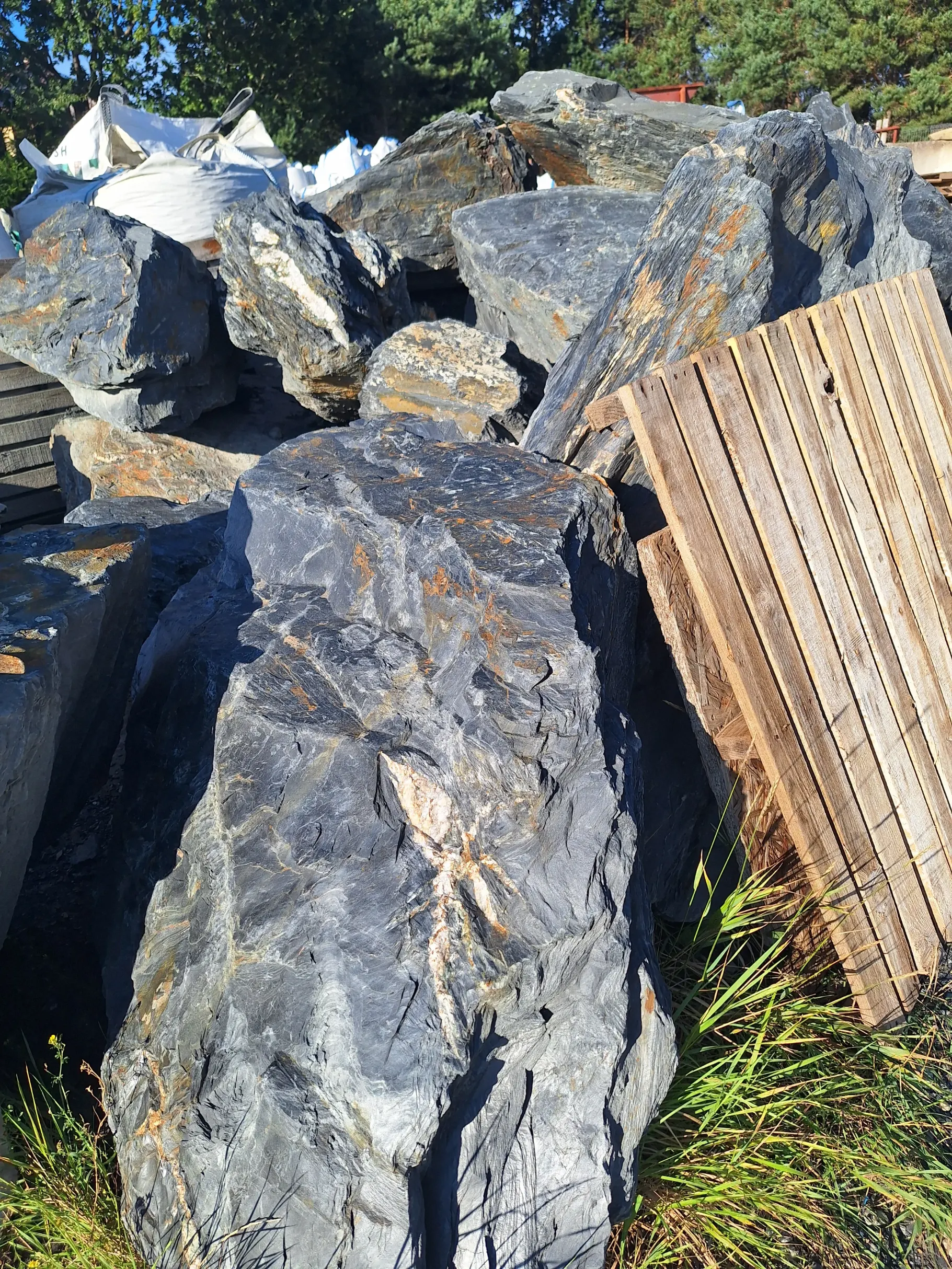 Nieregularne, ciemnoszare bryły bazaltu z pomarańczowymi żyłkami do gabionów