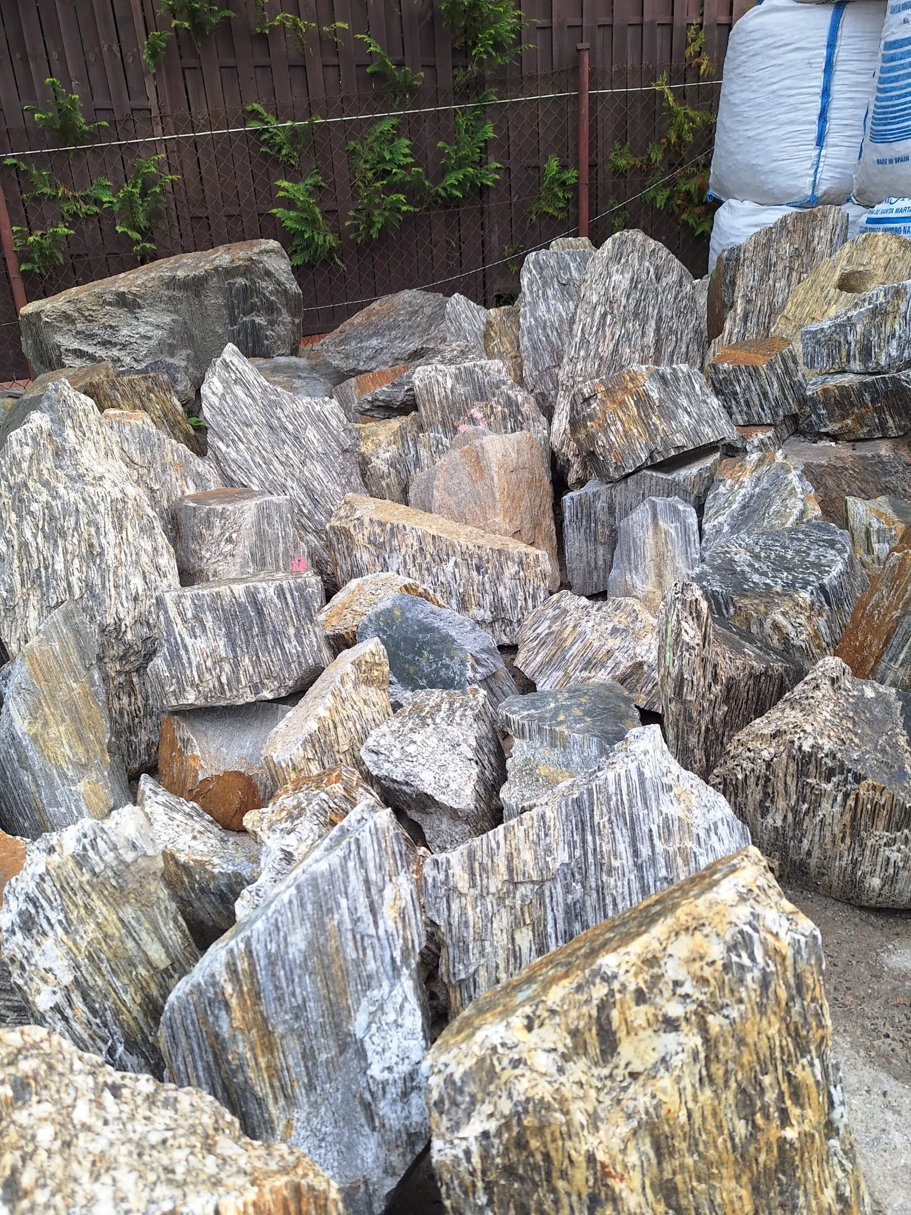 Surowe, pionowo ułożone bloki kamienia ozdobnego z widocznymi warstwami i rysunkiem