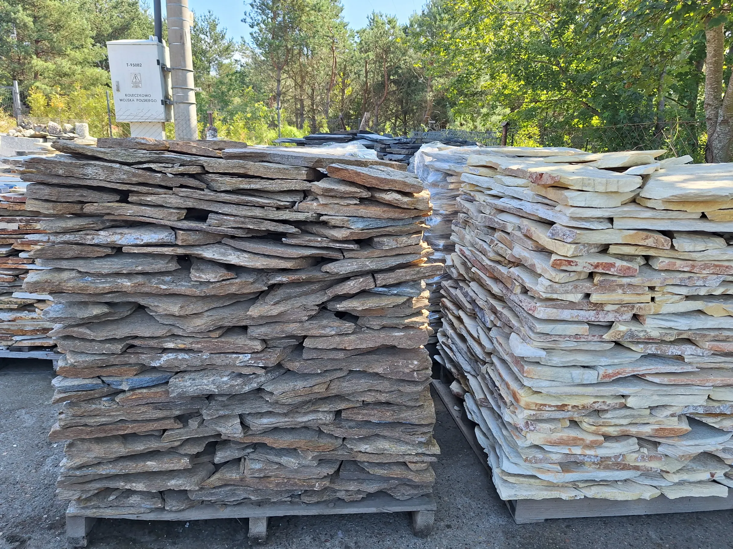 Nieregularne płytki Dolomit ułożone na paletach w składzie kamiennym