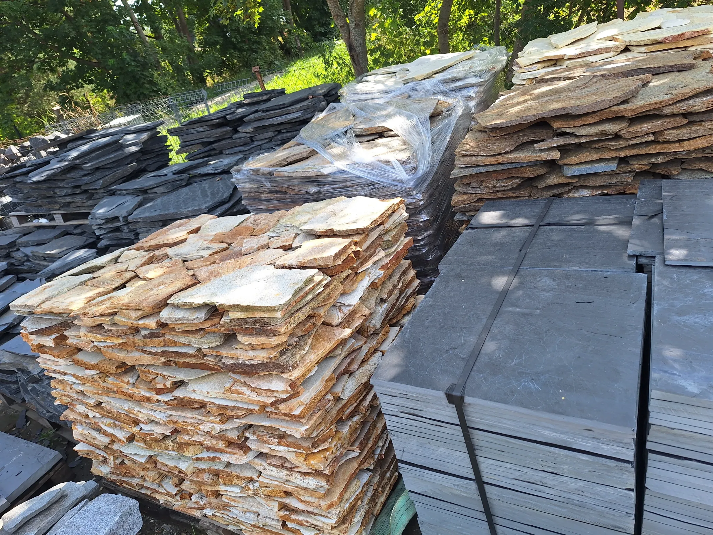 Stosy płyt ozdobnych z kamienia naturalnego w różnych kolorach gotowe do montażu