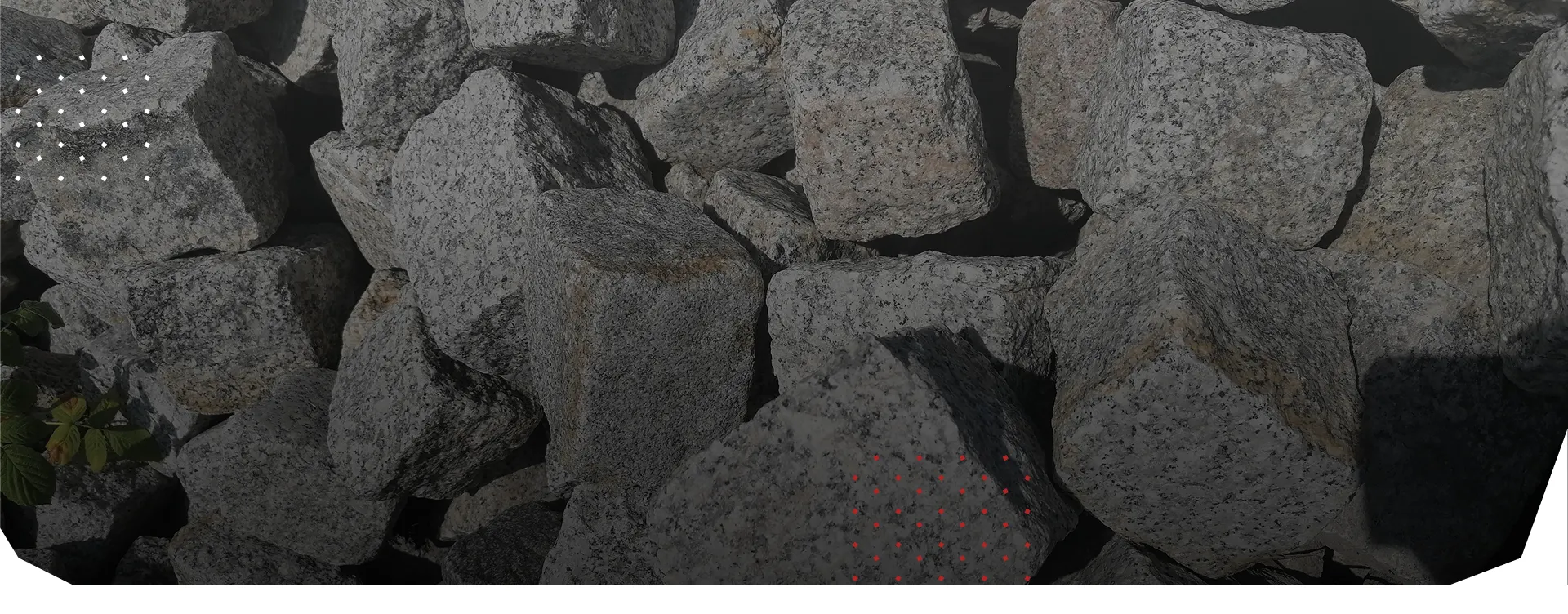 Stos nieregularnych szarych bloczków granitoidów o chropowatej fakturze, idealnych do dekoracji ogrodowych i murków gabionowych