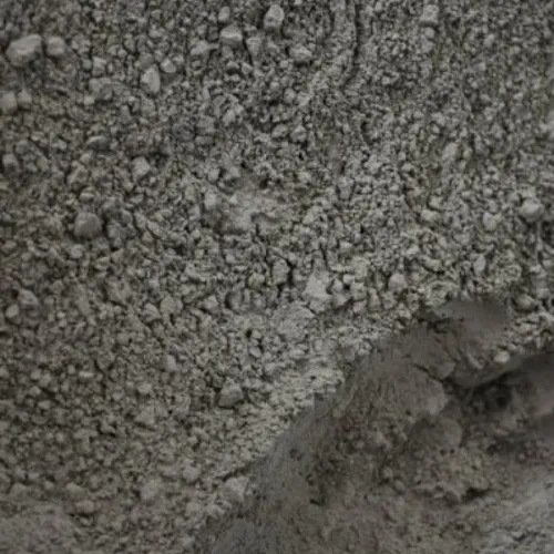 Drobne ziarna mączki bazaltowej w formie szarego proszku na nierównym podłożu